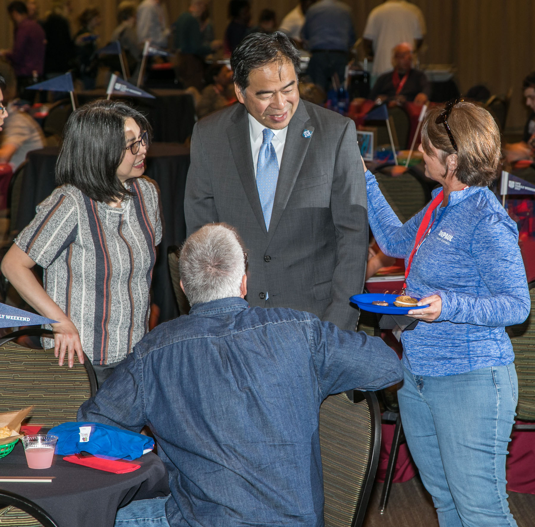 Josephine Esteban, left, and DePaul University President A. Gabriel Esteban, Ph.D., center, greet guests as students and family members gather for a buffet dinner and student performances at the Family Weekend Kickoff celebration. (DePaul University/Jamie Moncrief)